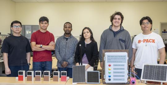 A group picture of students who worked during Summer of 2026 with their projects in front of them