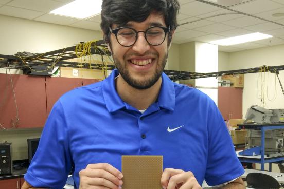 David House holding a prototype of the metasurface absorber