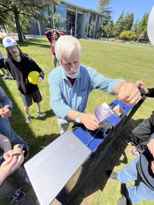 Picture of professor Rob Rowlands along with students preparing the balloon for launch