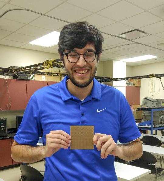 David House holding a prototype of the metasurface absorber