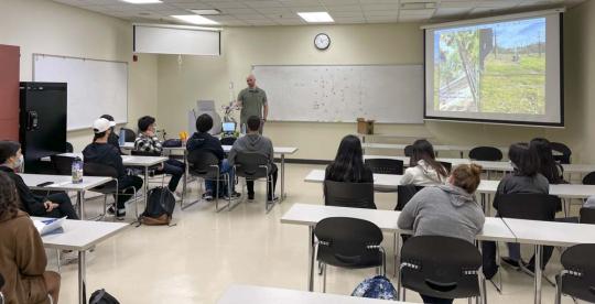 Picture of engineering alumni Scott Parmley talks to a group of high school students about his rover project and engineering career