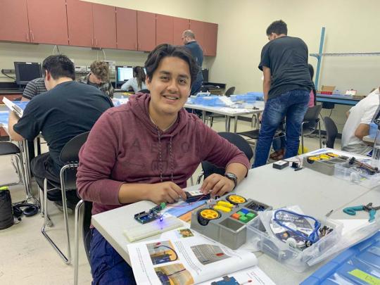 Picture of a high school student working with an Arduino microcontroller in an engineering lab
