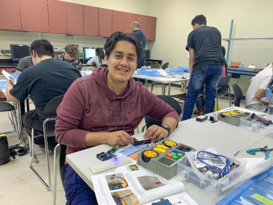 Picture of a high school student working with an Arduino microcontroller in an engineering lab