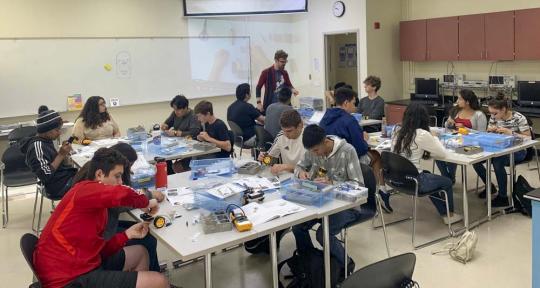 Picture of high school students building a robotic car during a summer camp program